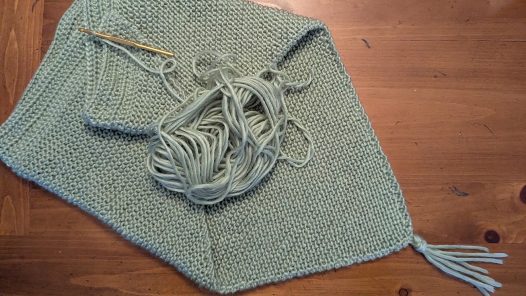 Crochet on a hand-knitted sage green shawl.